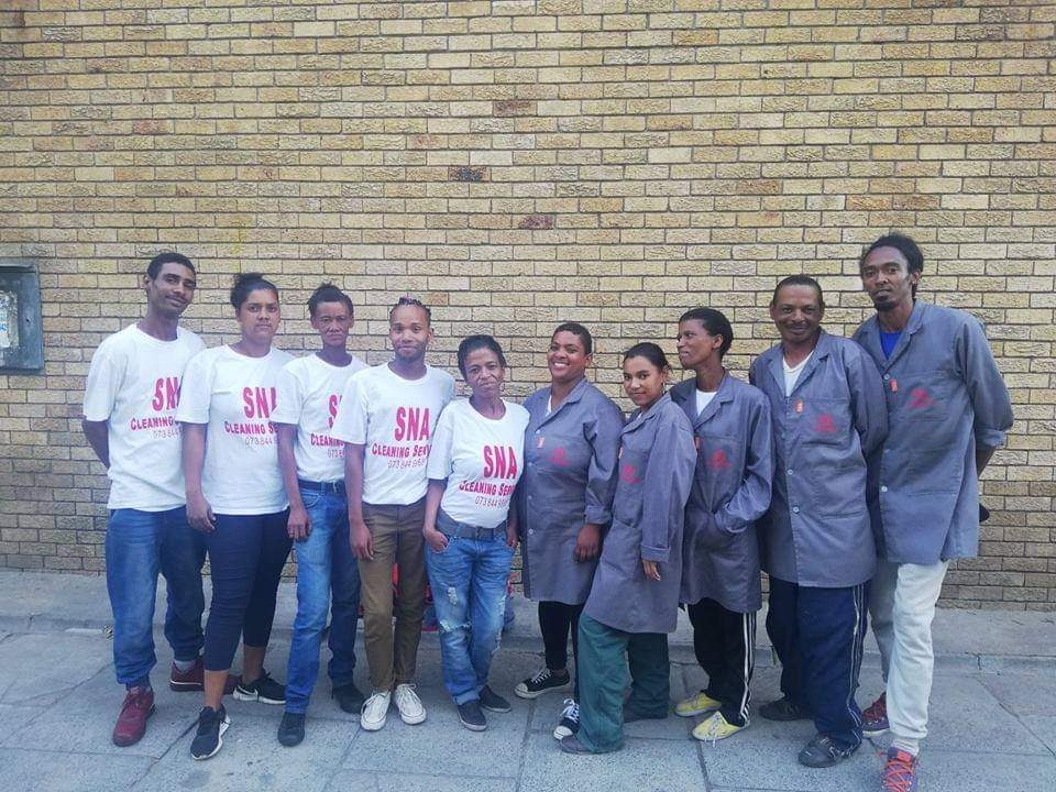 SNA Cleaning Services team in branded white shirts and work coats